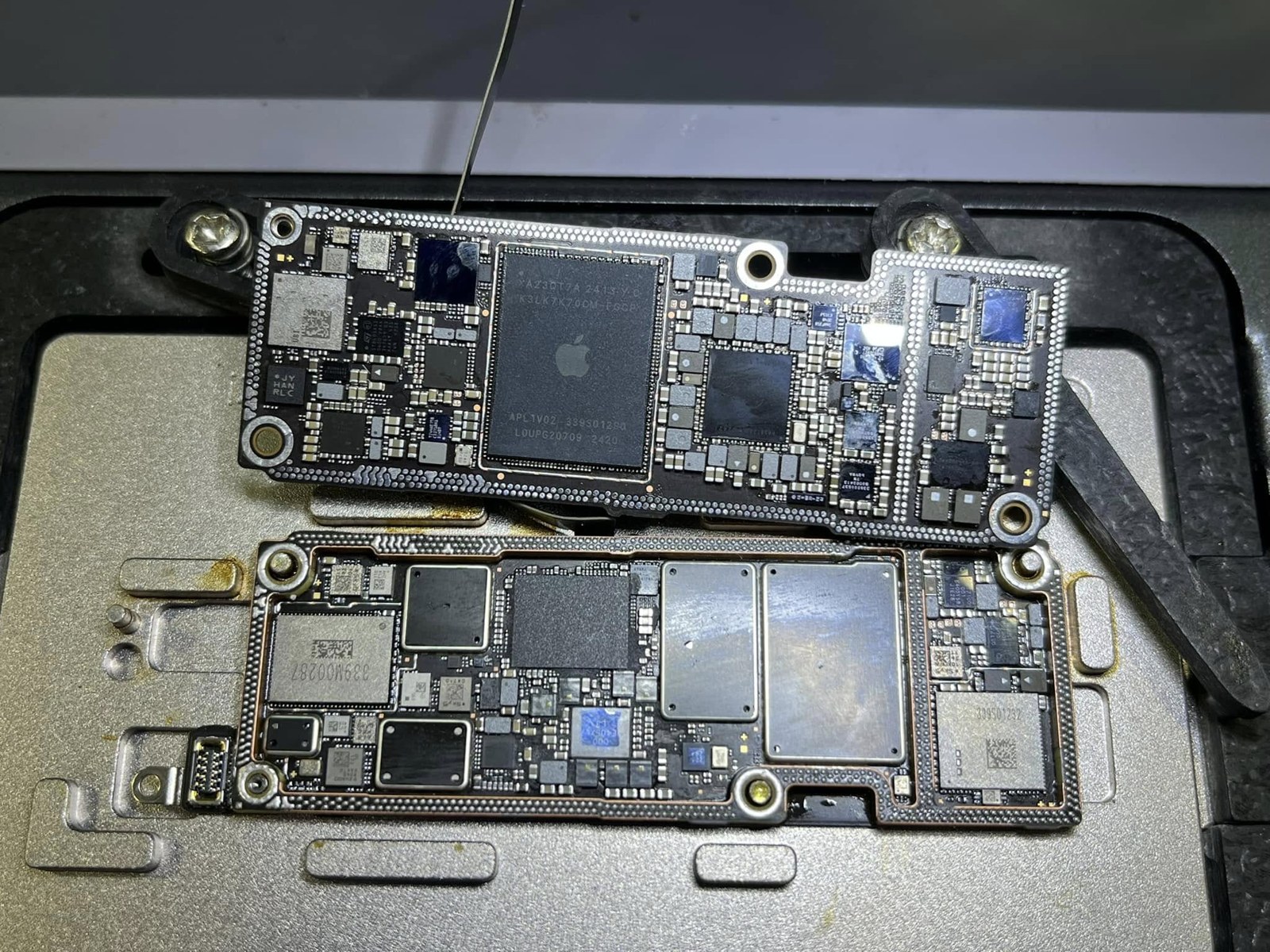 An opened iPhone motherboard on the repair bench at Supreme Cellular Repair