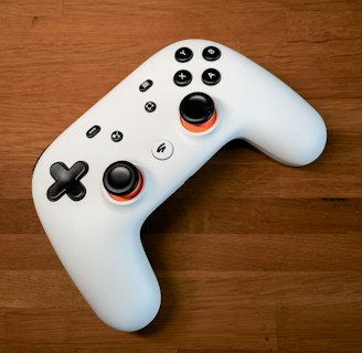 a white controller sitting on top of a wooden floor