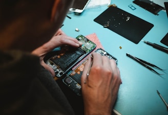 person repairing smartphones under a lighted table