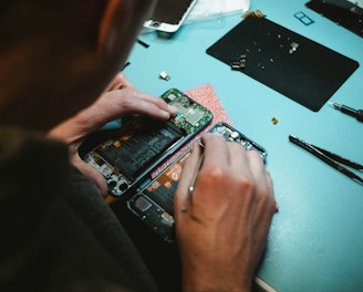 person repairing smartphones under a lighted table